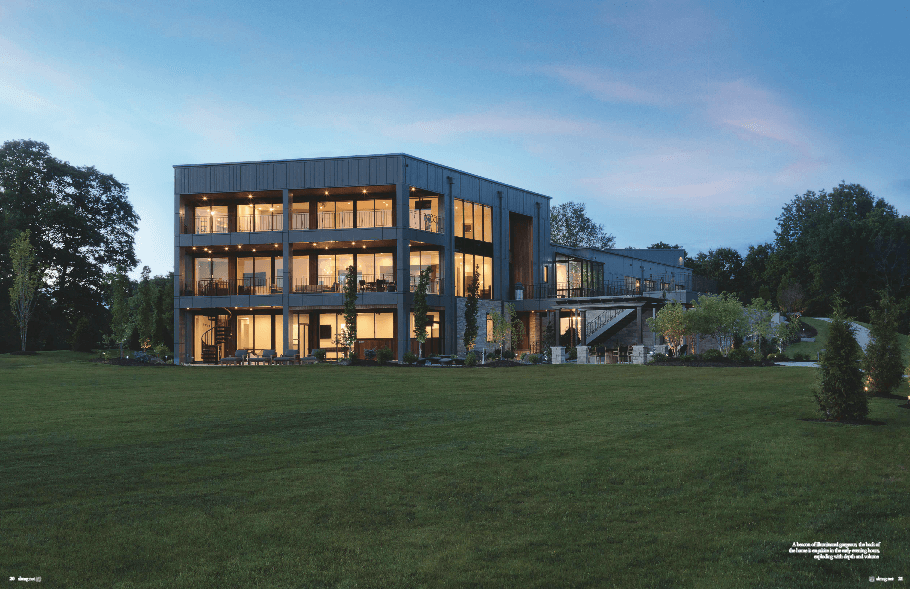 Exterior view of a modern home at night on the pages of Sophisticated Living magazine.
